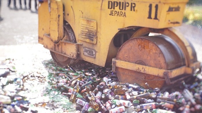 Pemkab Jepara Musnahkan Ribuan Miras selama Operasi PPKM 25 PEMUSNAHAN: Berbagai merek dan jenis miras sedang dihancurkan menggunakan mobil berat di depan Gedung Shima, Senin (29/11). (Adhik Kurniawan / Lingkarjateng.id)