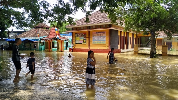 BASAH: Beberapa anak terlihat bermain air di salah satu lokasi banjir di Kecamatan Jakenan pada Jumat lalu (26/11). (Aziz Afifi / Lingkarjateng.id)