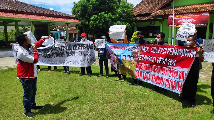 PROTES: Puluhan peserta seleksi perangkat desa menggelar aksi demo di Depan Kantor Kecamatan Lasem, Senin (22/11). (R. Teguh Wibowo / Lingkarjateng.id)