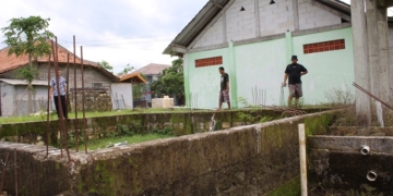 MANGKRAK: Rifki bersama rekannya meninjau lokasi gedung baru MWC NU Blora yang mendapatkan dana hibah dari Pemkab Blora, Selasa (23/11). (Lilik Yuliantoro / Lingkarjateng.id)