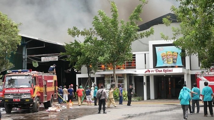 DIPADAMKAN: Suhu panas akibat terbakarnya Pabrik Dua Kelinci Pati membuat suasana mencekam, di jalan Raya Pati-Kudus, Margorejo, Pati, siang ini, Selasa (23/11). (Nailin Risydan Al Anshori / Lingkarjateng.id)