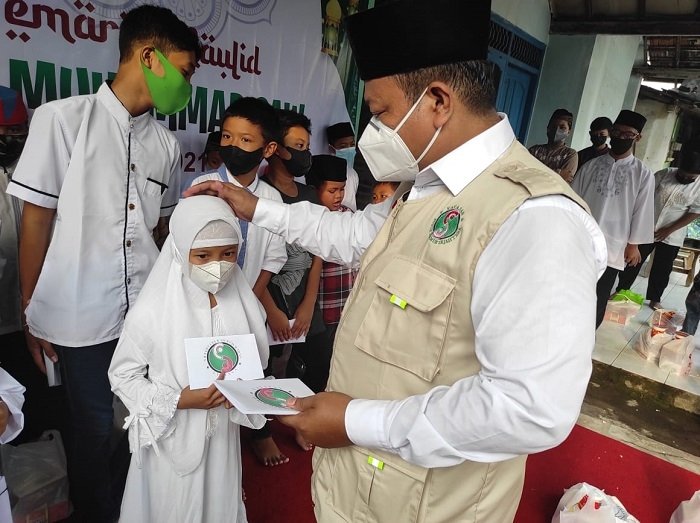 BERBAGI: Ketua Yayasan Subur Makmur Sejahtera tengah membagikan bantuan kepada anak yatim, piatu, dan dhufa di lingkungan Kampung Kranggan, Kelurahan Pati Kidul, Pati, beberapa waktu lalu. (Nailin Risydan Al Anshori / Lingkarjateng.id)