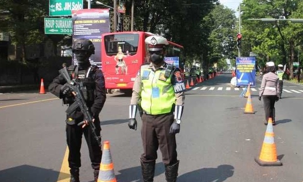 PENERTIBAN: Sejumlah petugas Polresta Surakarta saat melaksanakan operasi disiplin prokes dan tertib berlalu lintas di simpang tiga Faroka Jalan Slamet Riyadi Solo. (Istimewa / Lingkarjateng.id)