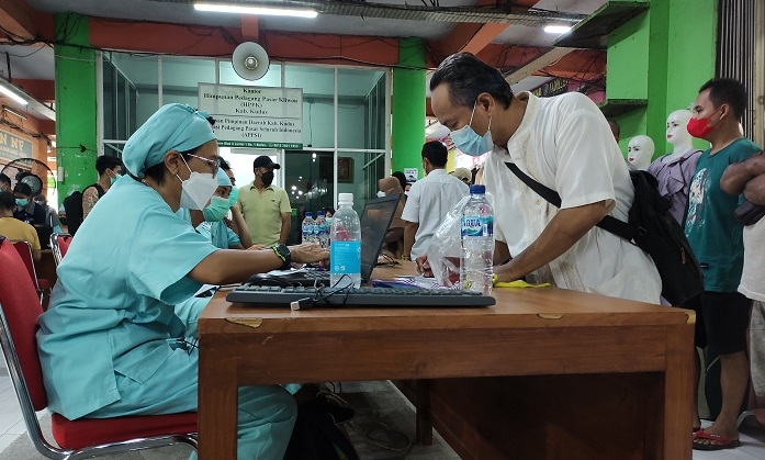 ANTUSIAS: Seorang warga sedang mendaftar untuk mengikuti vaksinasi jemput bola dari RS Mardi Rahayu di Pasar Kliwon Kudus, Sabtu (20/11). (Nisa Hafizhotus Syarifa / Lingkarjateng.id)