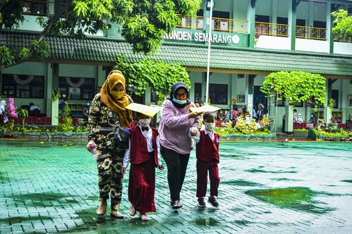 ILUSTRASI: Seorang ibu menjemput anaknya pulang sekolah. ((Dinda Rahmasari/Lingkarjateng.id)
