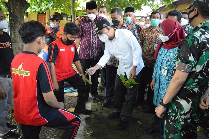 PENGHIJAUAN: Penanaman pohon di lingkungan sekolah untuk menciptakan hutan sekolah sebagai salah satu syarat menjadi sekolah Adiwiyata Mandiri di SMAN 1 Nalumsari, Jepara, Jumat (24/12). (Adhik Kurniawan/Lingkarjateng.id)