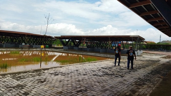 Selesai Dibangun, Pemkab Menunggu Penyerahan Alun-Alun Timur Pati 25 TERGENANG: Ketua Ormas Nasional Masyarakat Penjaga Nusantara (Mantra), Cahaya Basuki (Yayak Gundul) saat memantau hasil pembangunan Alun-Alun Timur Pati yang tergenang air saat hujan, kemarin. (Aziz Afifi/Lingkarjateng.id)