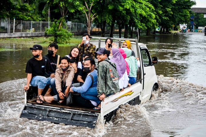 Jokowi Minta Ganjar Waspadai Cuaca Ekstrem di Jawa Tengah 25 TETAP CERIA: Beberapa pekerja pabrik berangkat kerja dengan menggunakan mobil pick up, karena motor mogok tergenang air di kawasan industri Pelabuhan Tanjung Emas. (Dinda Rahmasari / Lingkarjateng.id)
