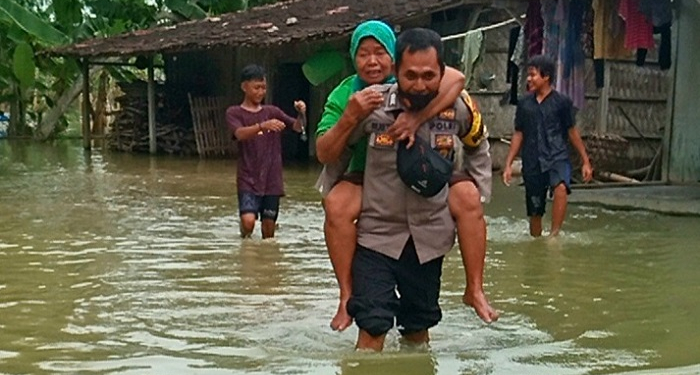 EVAKUASI: Bhabinkamtibmas Desa Lemahputih, saat membantu evakuasi warga yang rumahnya mengalami kebanjiran. (Muhamad Ansori / Lingkarjateng.id)