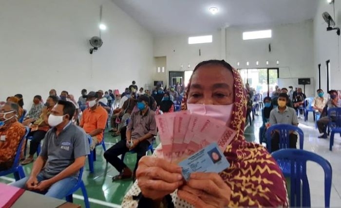 Penyaluran BLT Kudus Ditargetkan Selesai Pertengahan Desember 25 SUBSIDI: Penerima manfaat menunjukkan uang tunai dan KTP setelah mengambil bantuan langsung tunai (BLT) di Kabupaten Kudus. (Antara / Lingkarjateng.id)