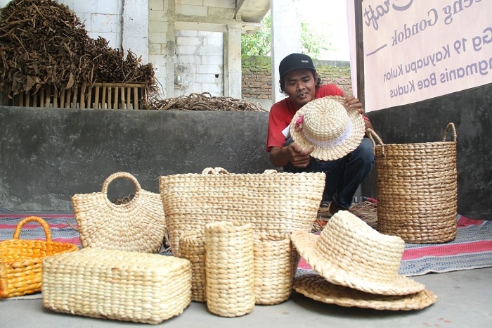 TERAMPIL: Ali Wahyudi sedang mengecek produk kerajinan eceng gondok buatannya supaya tidak ada kerusakan sebelum dijual kepada pembeli. (Nisa Hafizhotus Syarifa/Lingkarjateng.id)