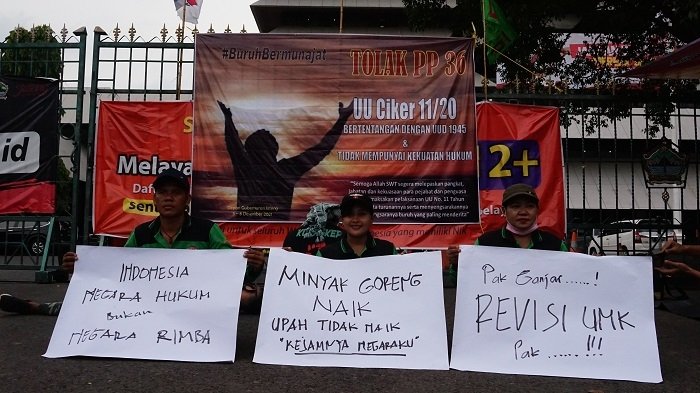AKSI: Sejumlah buruh memegang poster bertuliskan tuntutan mereka di depan Kantor Gubernur Jawa Tengah, belum lama ini. (M. Elang Ade Iswara / Lingkarjateng.id)
