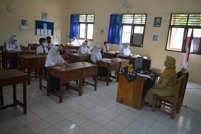 MENGAJAR: Seorang guru yang sedang menyampaikan materi saat Pembelajaran Tatap Muka (PTM) di salah satu SD di Kota Semarang. (Dinda Rahmasari / Lingkarjateng.id)