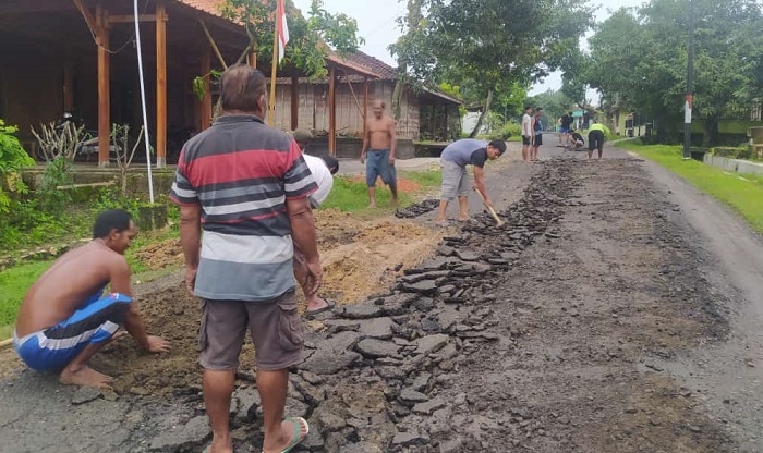 SWADAYA: Warga sedang bergotong-royong memperbaiki jalan rusak yang menghubungkan antara Desa Banjarejo dengan Desa Sendanggayam di Kecamatan Banjarejo, kemarin (23/12). (Lilik Yuliantoro/Lingkarjateng.id)