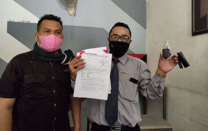 BARANG BUKTI: Assiry didampingi Kusnan selaku kuasa hukumnya sedang menunjukan surat gugatan beserta kunci mobil yang dirampas oleh pihak BCA Finance di PN Kudus, kemarin (8/12). (Nisa Hafizhotus Syarifa / Lingkarjateng.id)