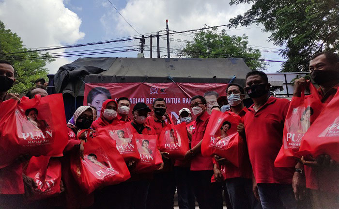 BAGI SEMBAKO: Anggota DPR RI sekaligus politisi PDI P Musthofa menyalurkan bantuan sembako kepada kader PDI P Kabupaten Kudus di dalam tas bertuliskan Puan Maharani, Jumat (31/12). (Nisa Hafizhotus Syarifa/Lingkarjateng.id)