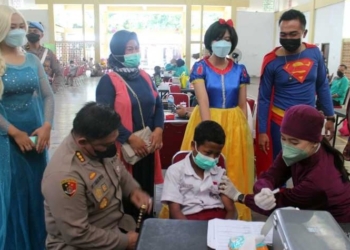 MEMOTIVASI: Kepala Polresta Surakarta Kombes Pol Ade Safri Simanjutak saat memberi semangat siswa SD dalam kegiatan vaksinasi anak usia 6-11 tahun di Gelora Bung Karno Manahan Solo, Rabu (22/12). (Istimewa/Lingkarjateng.id)