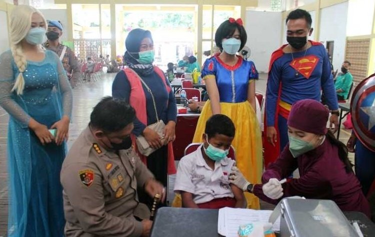 MEMOTIVASI: Kepala Polresta Surakarta Kombes Pol Ade Safri Simanjutak saat memberi semangat siswa SD dalam kegiatan vaksinasi anak usia 6-11 tahun di Gelora Bung Karno Manahan Solo, Rabu (22/12). (Istimewa/Lingkarjateng.id)