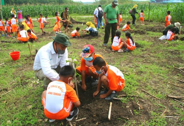 Lestarikan Hutan, Perhutani Grobogan Ajak Anak TK Tanam Pohon 25 MENANAM: Administratur KPH Gundih bersama Anak TK Tunas Rimba Cabang Gundih menanam pohon bersama anak-anak TK di kawasan hutan RPH PEPE BKPH Monggot Perhutani KPH Gundih, Rabu (8/12). (Muhamad Ansori / Lingkarjateng.id)
