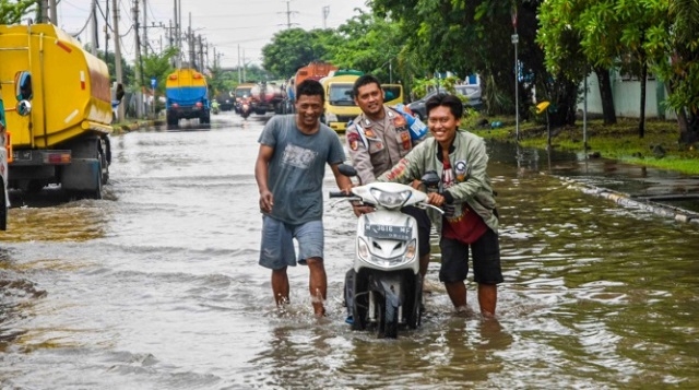 BPBD Semarang Imbau Warga Waspadai Bencana 25 BANJIR: Beberapa orang sedang mendorong motor melewati genangan banjir di salah satu wilayah di Kota Semarang beberapa waktu lalu. (Dinda Rahmasari/Lingkarjateng.id)