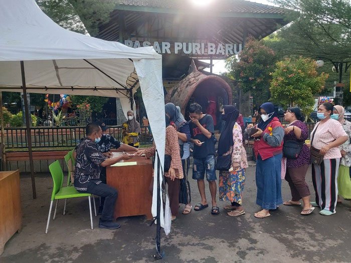 Atasi Lonjakan Harga Minyak Goreng, Disdagperin Pati Lakukan Penetrasi 25 ANTRI: Sejumlah warga mengantri minyak goreng yang dipenetrasikan oleh Disperindag Pati di halaman Pasar Puri Baru, Jumat (31/12/2021). (Aziz Afifi/Lingkarjateng.id)