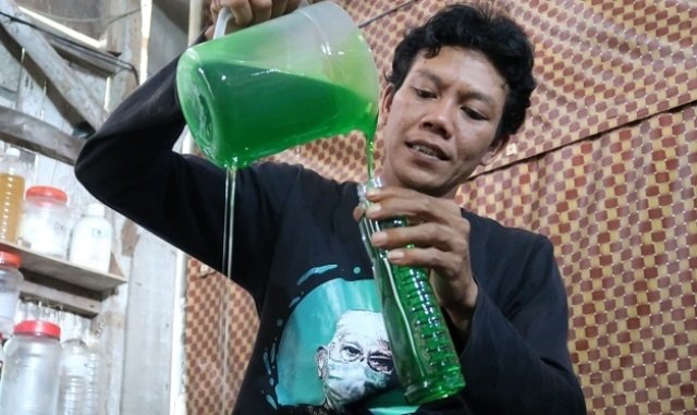 MENGEMAS: Tharikun mengemasi sabun cuci piring produksinya. (R. Teguh Wibowo/Lingkarjateng.id)