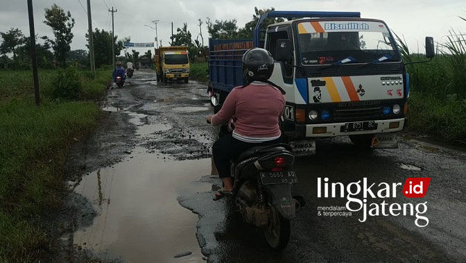 RUSAK: Warga berhati hati saat melintasi Jalan Raya Margoyoso-Damarjati di Kecamatan Kalinyamatan, kemarin (17/1). (Muslichul Basid/Lingkarjateng.id)