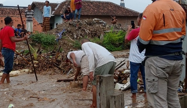 KERJA BAKTI: Warga membersihkan sampah di jembatan akibat banjir. (Istimewa/Lingkarjateng.id)