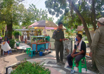 STERILISASI: Regu unit Satuan Polisi Pamong Praja (Satpol PP) Kabupaten Demak menegur Pedagang Kaki Lima (PKL) di pinggir Jl. Bhayangkara Baru, Demak, Senin (24/1). (M. Elang Ade Iswara/Lingkarjateng.id)