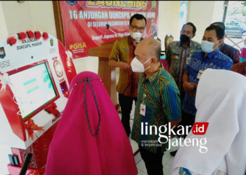 UJI COBA: Bupati Jepara mendampingi salah satu pelajar untuk mencetak KTP di Anjungan Dukcapil Mandiri. (Muslichul Basid/Lingkarjateng.id)