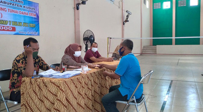 Alokasi Dana Desa di Kudus Turun 25 MENYERAHKAN: Pembagian BLT Dana Desa di Kudus, beberapa waktu yang lalu. (Alifia Elsa Maulida/Lingkarjateng.id)