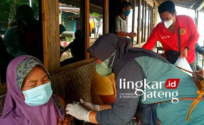 VAKSIN: Petugas dari Binda Jateng dan Puskesmas Karangrayung I saat memberikan vaksinasi dan sembako ke warga Sumberejo Sari, Karangrayung, Selasa (18/1). (Muhamad Ansori/Lingkarjateng.id)