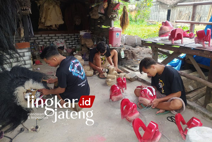 BERKARYA: Taufik, pengurus kelompok barongan bersama teman-temannya saat membuat kerajinan barongan. (Lilik Yuliantoro/Lingkarjateng.id)