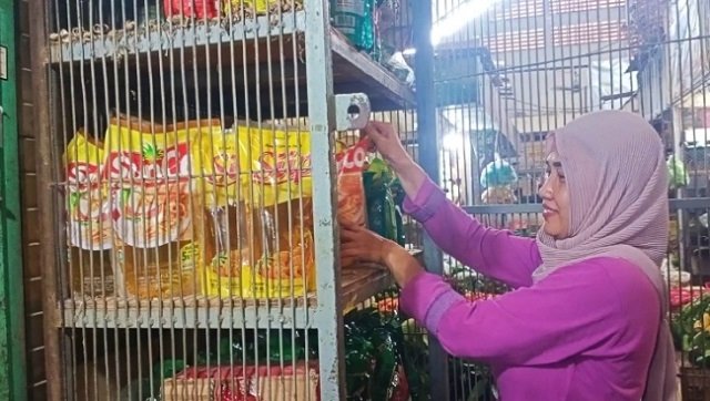 MENJUAL: Salah satu pedagang di Pasar Bitingan Kudus saat menata minyak goreng di kios, Rabu (19/1). (Alifia Elsa Maulida/Lingkarjateng.id)