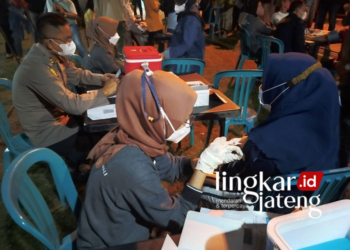 VAKSIN: Polres Demak adakan vaksinasi booster untuk masyarakat umum di Alun-Alun Simpang Enam Demak, Sabtu (22/1) malam. (Dok. Humas Polres/Lingkarjateng.id)