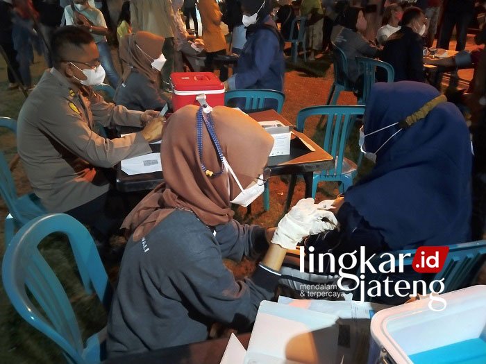 VAKSIN: Polres Demak adakan vaksinasi booster untuk masyarakat umum di Alun-Alun Simpang Enam Demak, Sabtu (22/1) malam. (Dok. Humas Polres/Lingkarjateng.id)