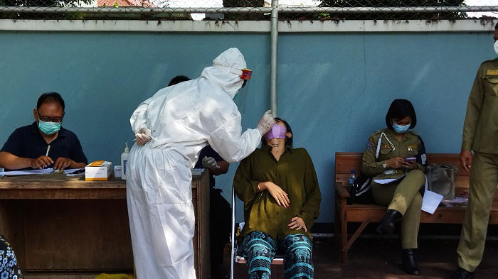 PELANGGARAN: Seorang pelanggar PPKM sedang di-swab oleh petugas, beberapa hari yang lalu. (Aziz Afifi/Lingkarjateng.id)