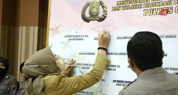 MENANDATANGANI: Bupati Grobogan, Sri Sumarni bersama Kapolres Grobogan, AKBP Benny Setyowadi dan Forkopimda menandatangani pencanangan pembangunan ZI, WBK, WBBM di Aula Jananuraga Mapolres setempat, Senin (7/2).