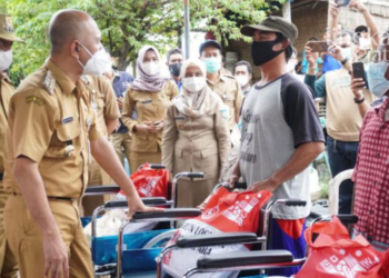 SIMBOLIS: Bupati Jepara Dian Kristiandi menyerahkan bantuan kepada nelayan di Desa Kedungmalang.