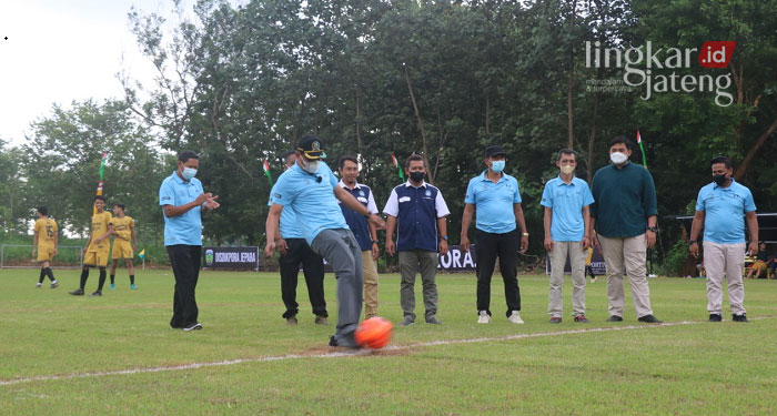 SIMBOLIS: Ketua DPRD Jepara, Haizul Ma'arif menendang bola sebagai pembukaan turnamen sepak bola Piala DPRD Jepara tahun 2022 di Lapangan Margodadi. (Muslichul Basid/Lingkarjateng.id)