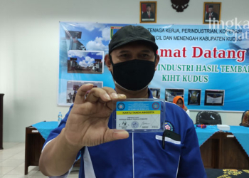 MENUNJUKKAN: Ketua PUK SP PT Djarum Ali Muslikin saat menunjukkan kartu anggota yang bisa digunakan untuk memperoleh potongan harga dari UMKM setempat.
