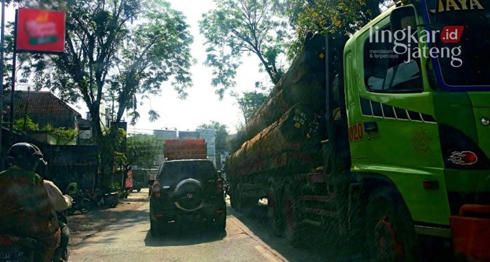 MELINTAS: Sebuah truk besar pengangkut kayu gelondongan melintas di ruas Jalan Tegowanu-Purwodadi-Blora, Selasa (29/3). (Muhamad Ansori/Lingkarjateng.id)