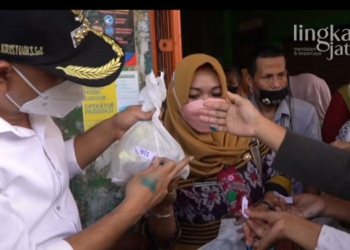 MENDISTRIBUSIKAN: Bupati Jepara Dian Kristiandi membagikan minyak goreng bersubsidi kepada warga. (Muslichul Basid/Lingkarjateng.id)