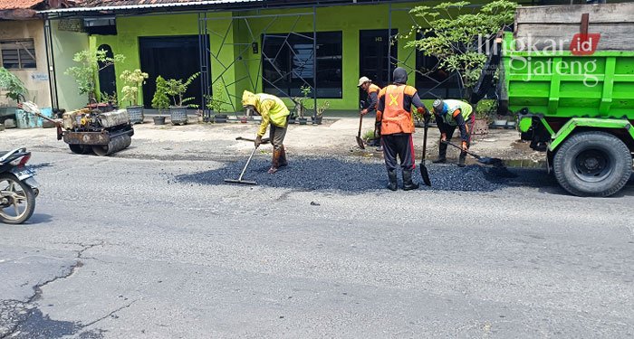 Sempat Dikeluhkan Warga, Jalan Raya Gotri-Welahan Jepara Akhirnya Diperbaiki 25 KERJA KERAS: Para pekerja sedang memperbaiki jalan raya Gotri-Welahan Kabupaten Jepara yang berlubang. (Muslichul Basid/Lingkarjateng.id)