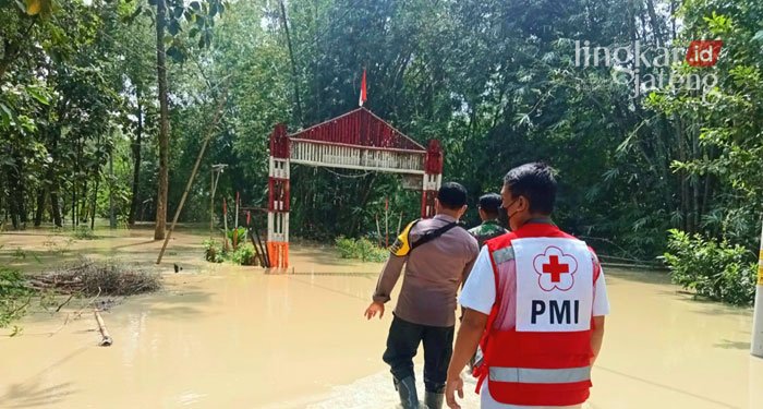 EVAKUASI: Relawan sedang membantu evakuasi warga di sekitar bantaran Sungai Serang, Desa Cingkrong, Grobogan pada Selasa (15/3). (Muhamad Ansori/Lingkarjateng.id)