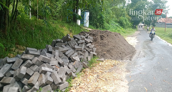 PERSIAPAN: Tumpukan material untuk perbaikan jalan Komplek Makam Tegalsari, Blora. (Lilik Yuliantoro/Lingkarjateng.id)