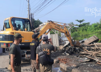 MEROBOHKAN: Petugas dari Satuan Polisi Pamong Praja (Satpol PP) Kota Semarang saat merobohkan lapak liar di Jalan Arteri Yos Sudarso. (Dok. Pemkot Semarang/Lingkarjateng.id)