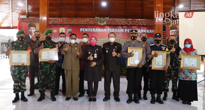 SIMBOLIS: Bupati Grobogan, Sri Sumarni foto bersama dengan garda terdepan Covid-19 usai menyerahkan penghargaan di Pendopo Kabupaten Grobogan, Kamis (31/3). (Muhamad Ansori/Lingkarjateng.id)