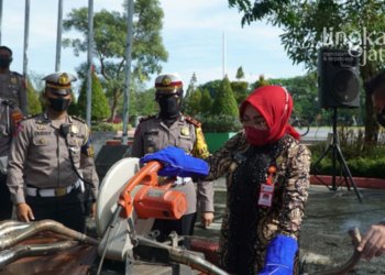 MEMUSNAHKAN: Bupati Grobogan, Sri Sumarni saat memotong knalpot brong dengan gergaji, Kamis (28/4). (Muhamad Ansori/Lingkarjateng.id)