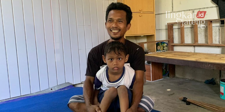 Nunggak BPJS, Anak Berkebutuhan Khusus Ditolak Berobat RSUD Kendal 25 IBA: MFA bersama orang tuanya, tampak MFA belum bisa berjalan dan hanya duduk. (Unggul Priambodo/Lingkarjateng.id)
